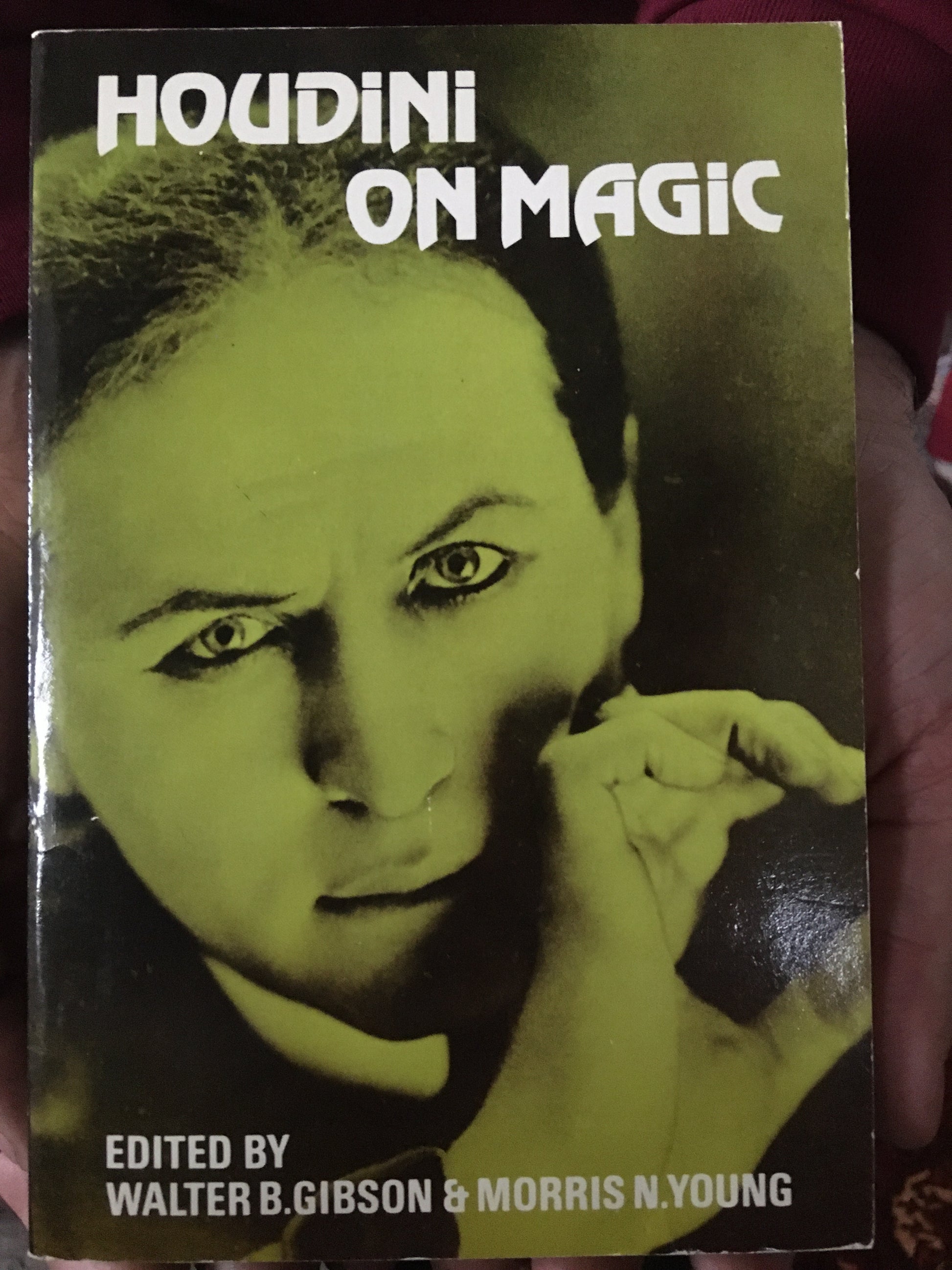 A used book cover of 'Houdini on Magic' featuring a green-tinted photograph of Houdini with a pensively looking expression, edited by Walter B. Gibson & Morris N.