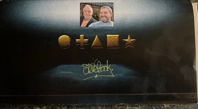 Black card with gold symbols and 'Steve Cook' branding on box