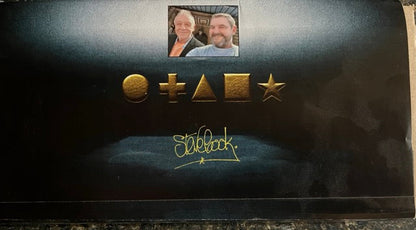 Black card with gold symbols and 'Steve Cook' branding on box